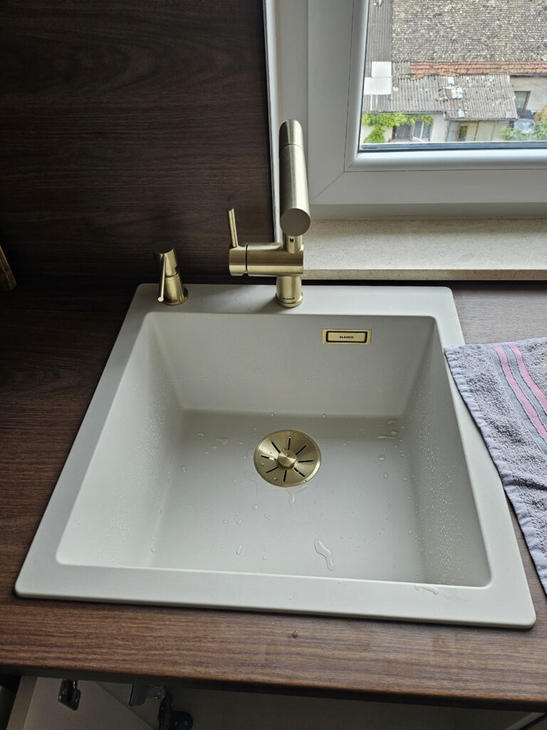 Montaža slavine sa izvlačnim izlivom na beloj kuhinjskoj sudoperi